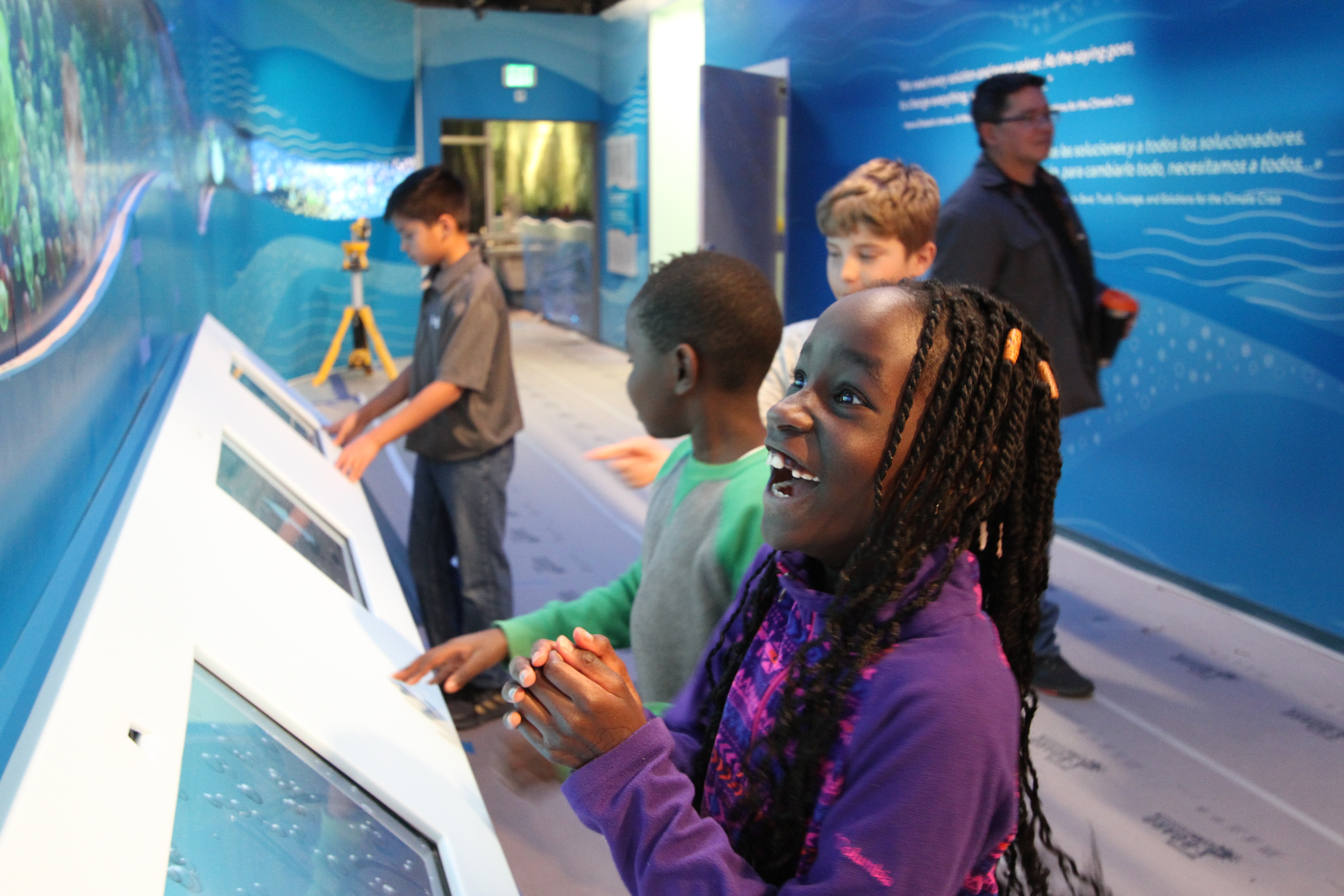 A group of children having fun interacting with hands-on exhibits in the WaterShed exhibit hall.