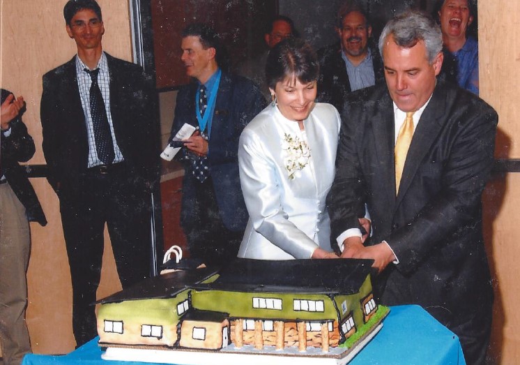 Mayor Dave Bieter helping cut a cake made to look like The WaterShed building.