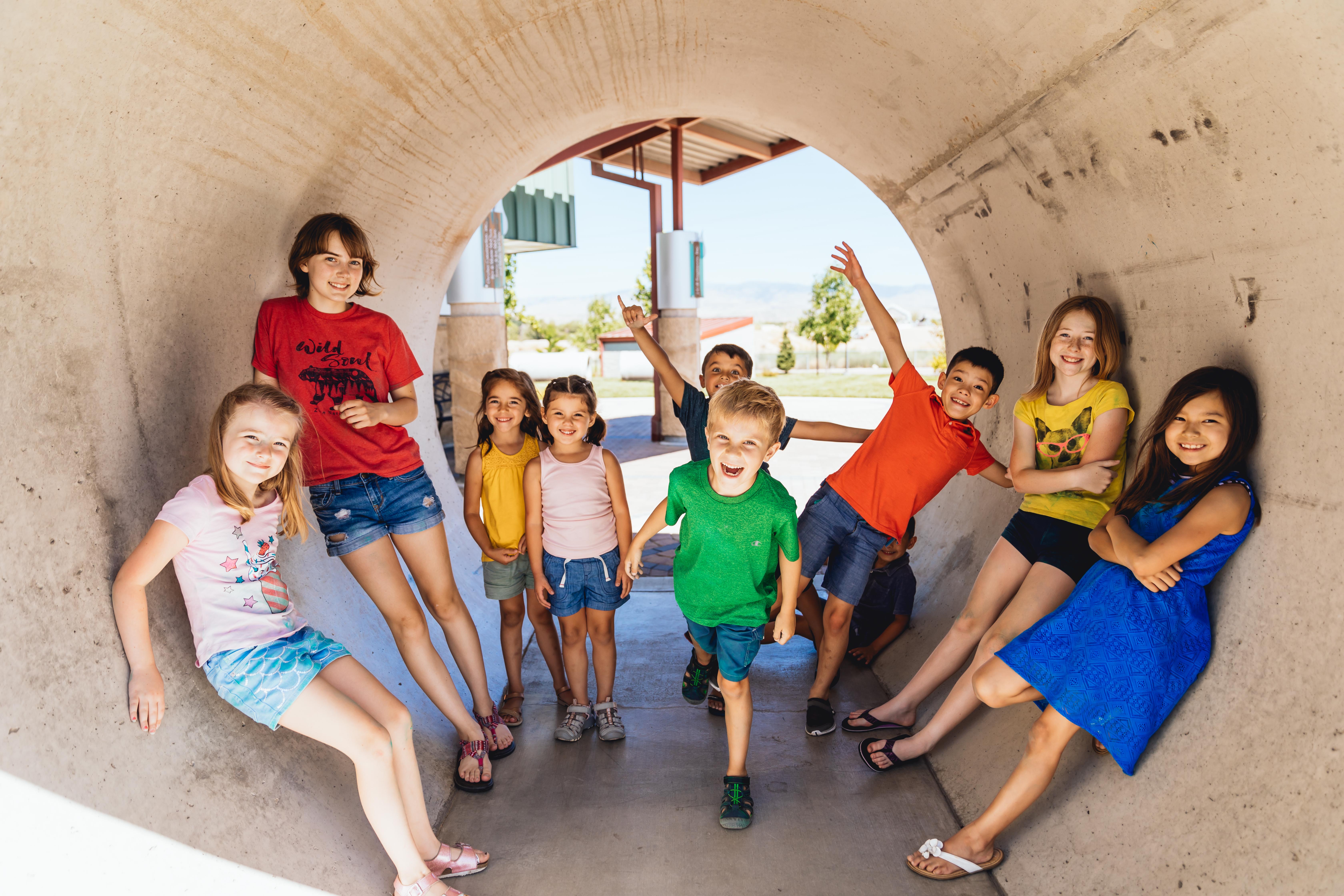 A group of kids having fun inside a large concrete tube.