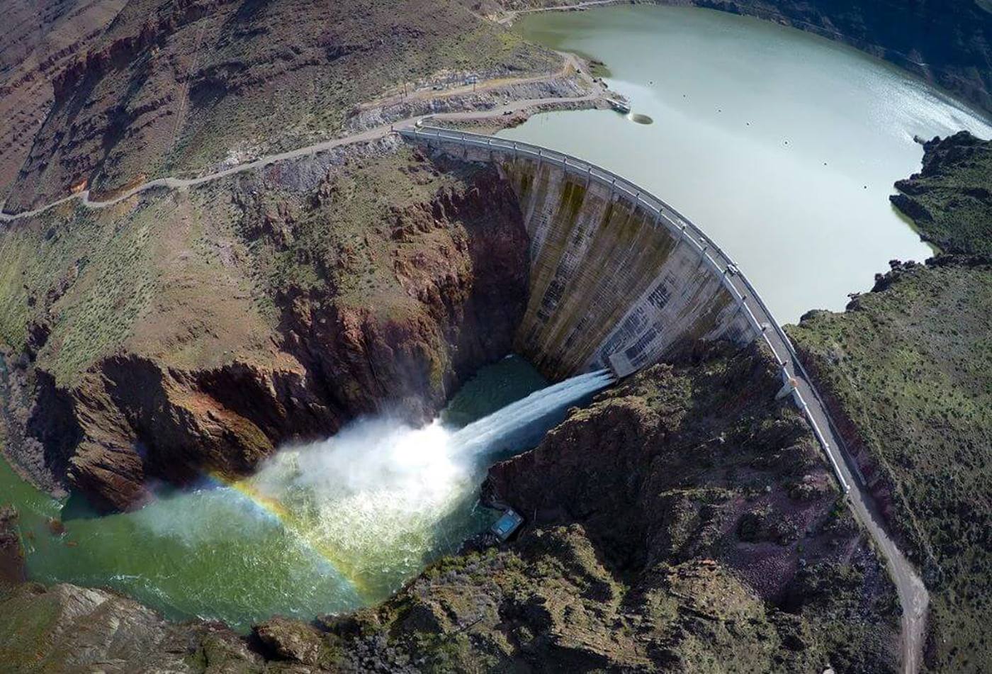 Owyhee Dam letting a controlled flow of water from the reservoir into a river canyon.