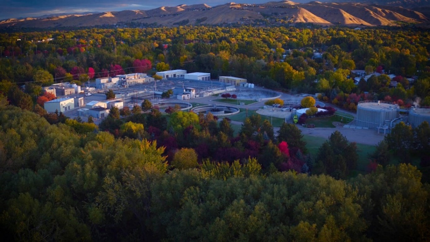 The campus of a water treatment facility, surrounded by dense trees.